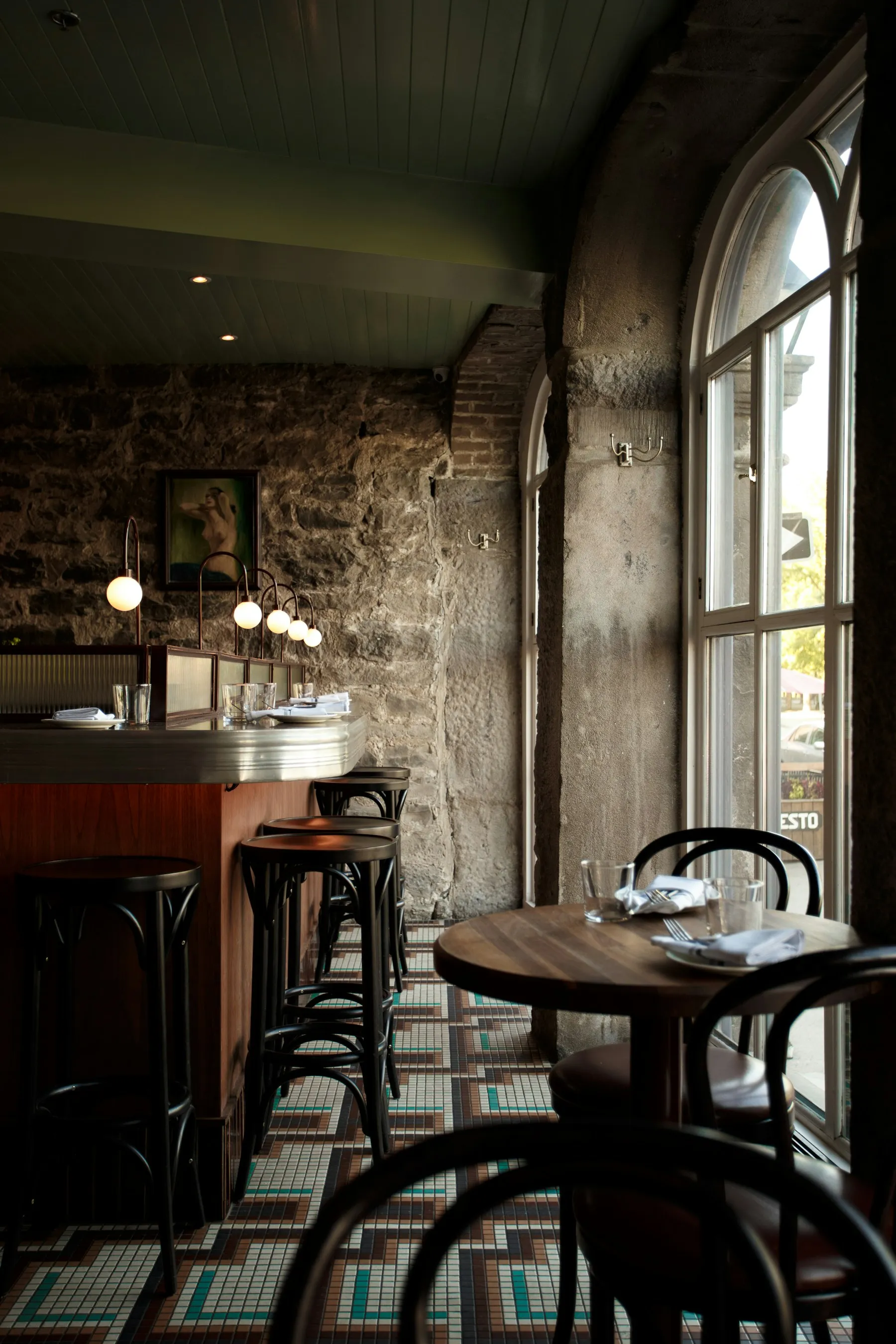 Bistrot aux murs de pierre baigné de lumière