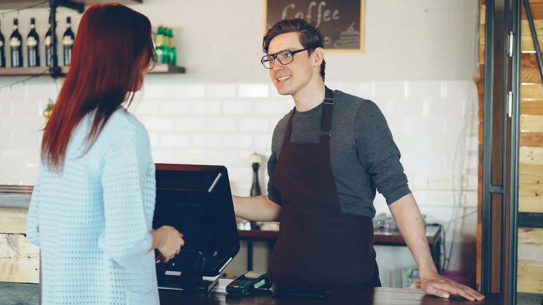 Cliente réglant sa commande au comptoir d'un café