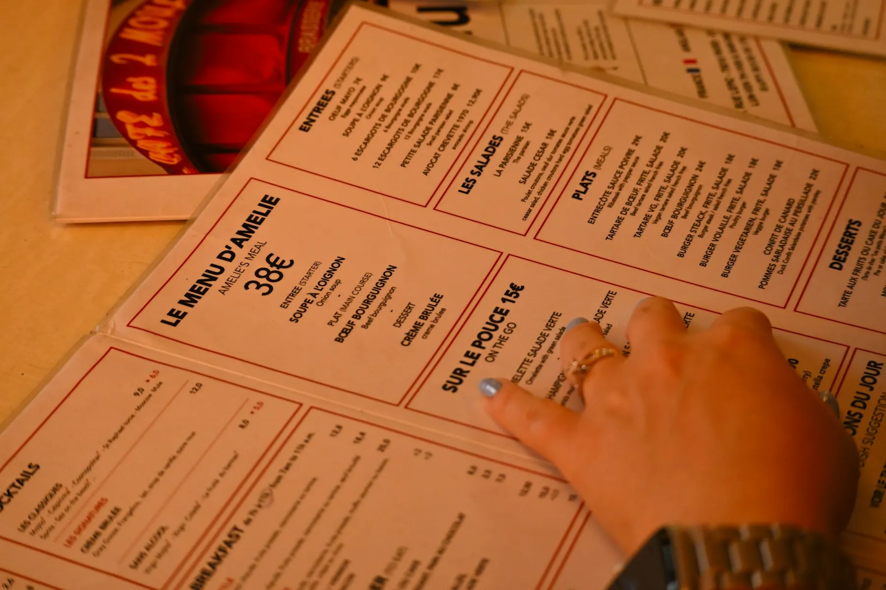 Main posée sur une carte de restaurant en papier