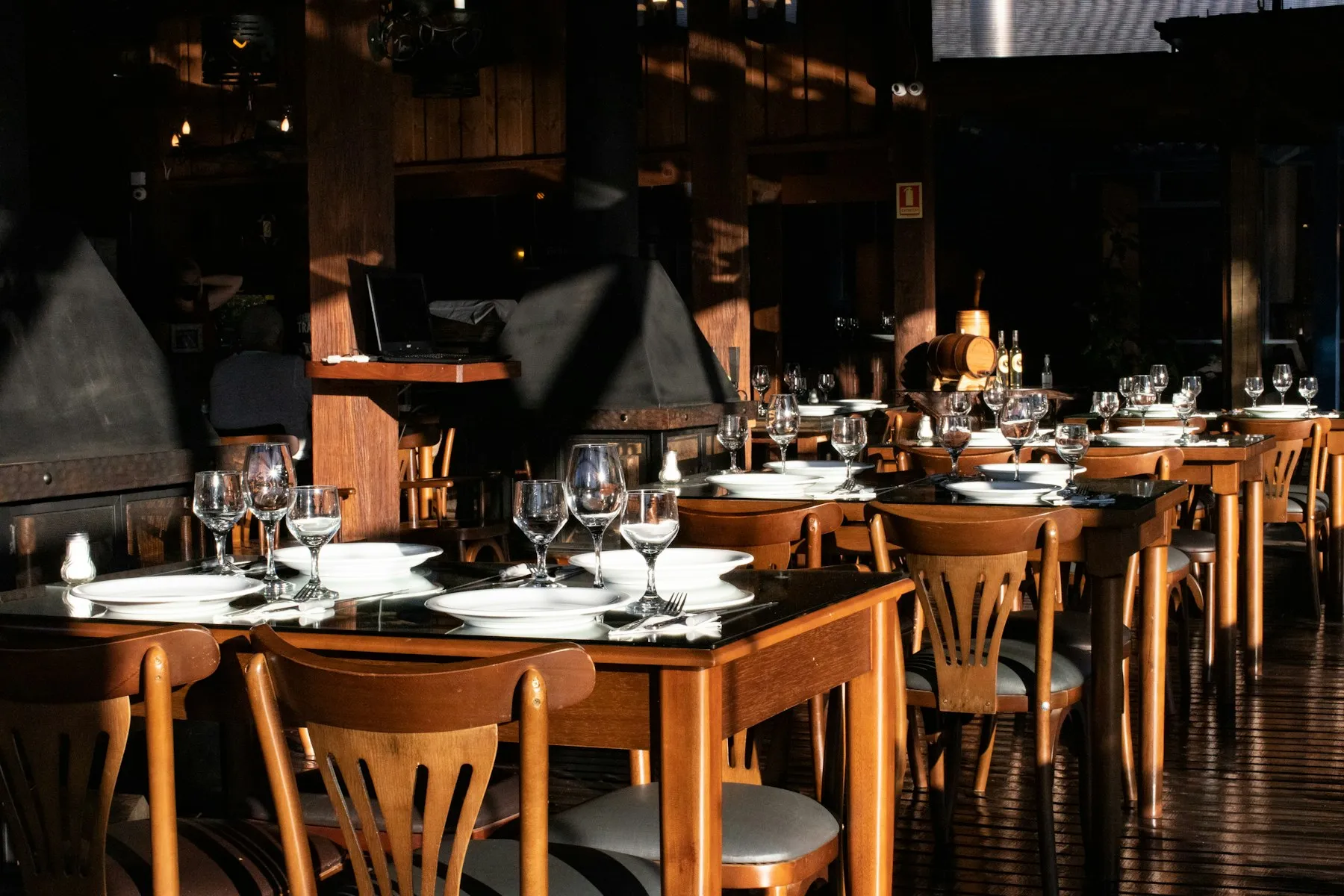 Salle de restaurant en bois avec des tables dressées